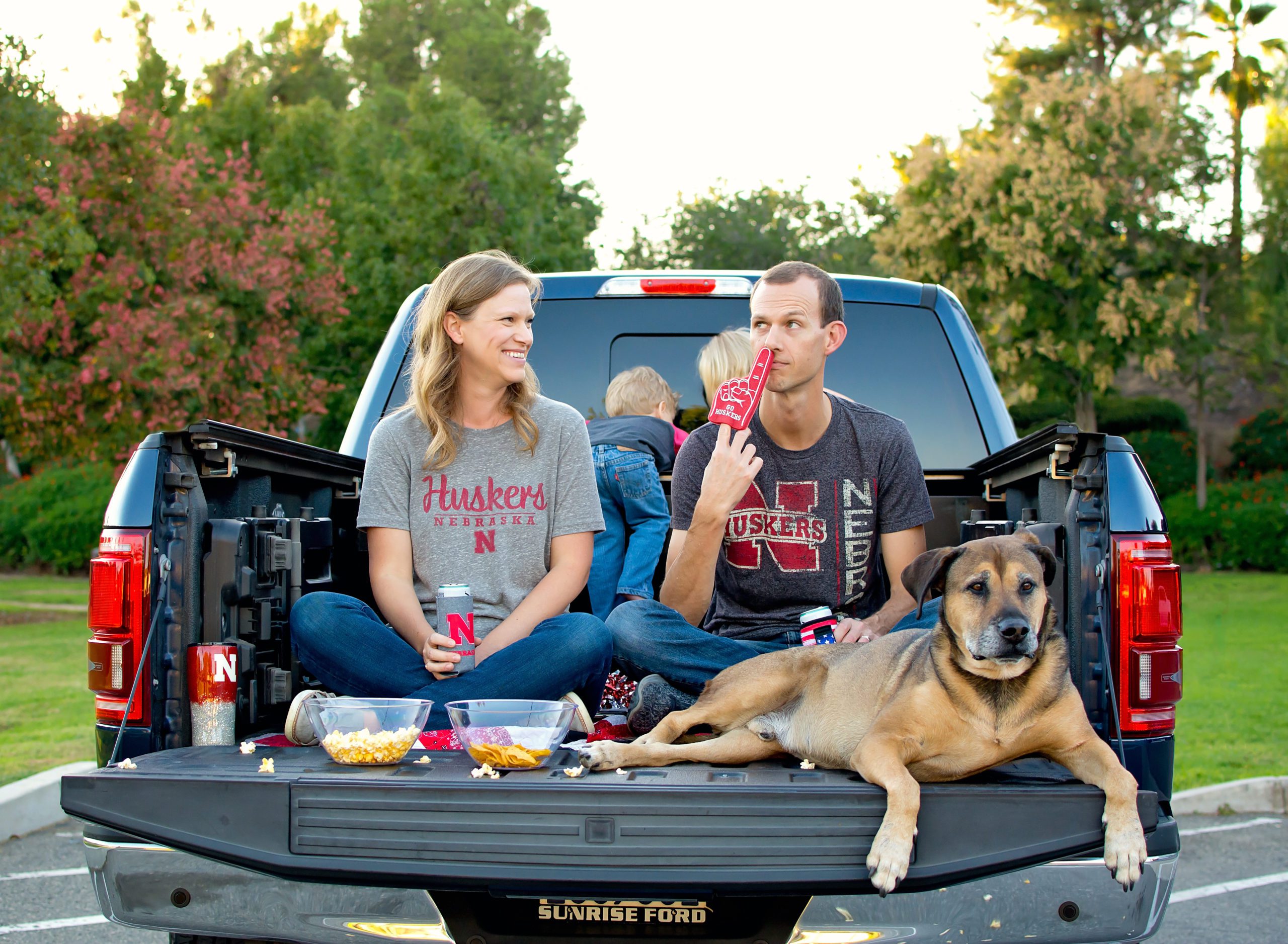 Riverside Family Photographer. Family in the back of a truck holding up foam fingers