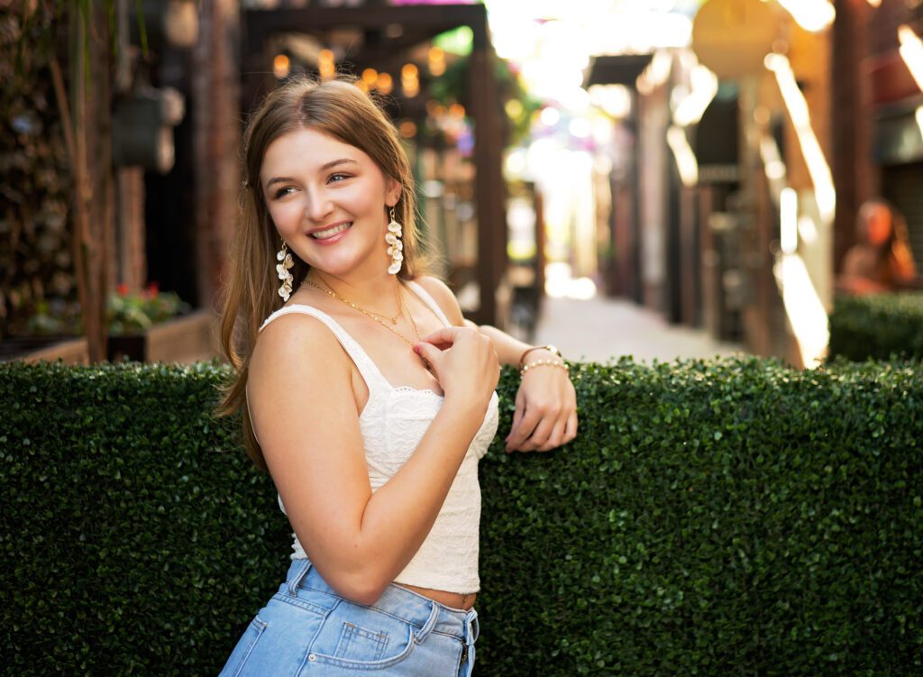 High School Senior photoshoot in Downtown Redlands.
Girl smiling and looking to the side in Umbrella Alley.